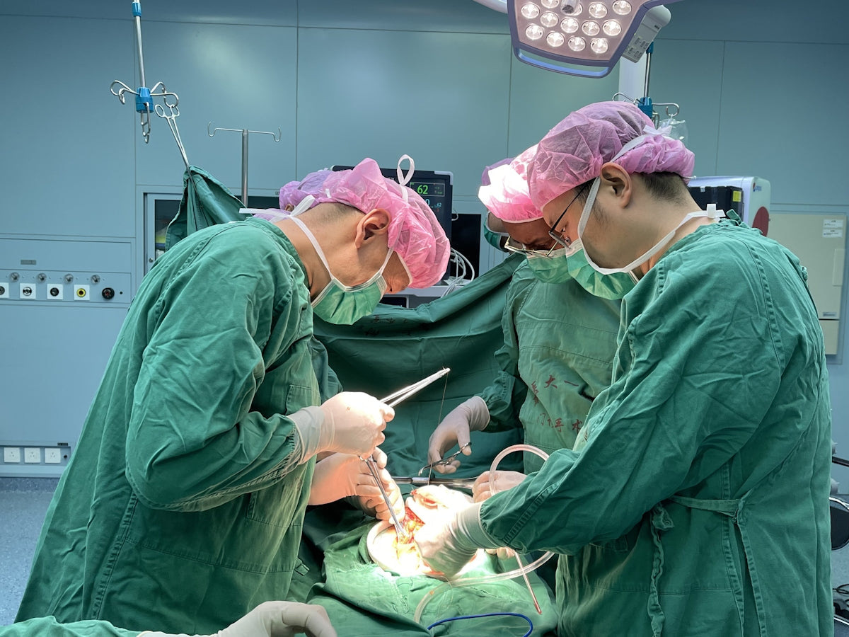 Surgeons performing a medical operation in a hospital operating room.